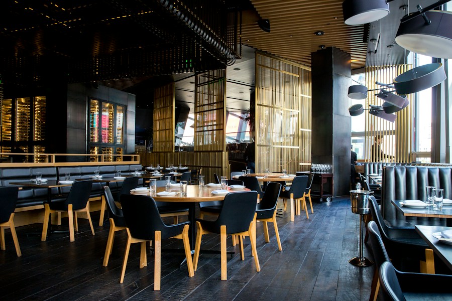 Interior de un restaurante con mesas de madera y luz cálida